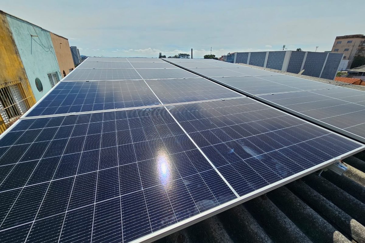 Longas fileiras de módulos solares sobre telhado comercial de fibrocimento